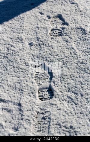 Closeup of footsteps in snow going forward. Exploring, adventure, journey concept Stock Photo