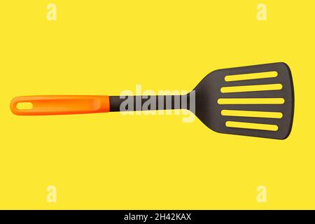 A black plastic spatula with orange handle Stock Photo
