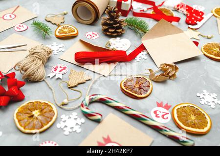 Preparing the Advent Calendar. Eco craft envelopes with gifts for children. Seasonal Christmas tradition. Stock Photo