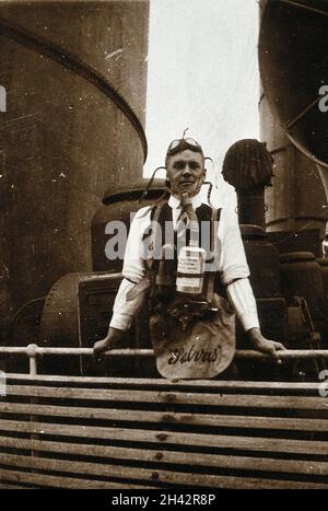 Ship fumigation using hydrogen cyanide: an operator wearing protective oxygen breathing apparatus. Photograph by P. G. Stock, 1900/1920. Stock Photo