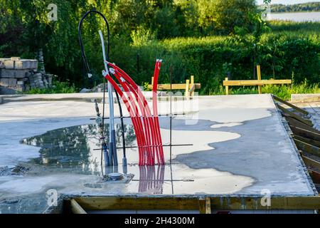 prepared cement base for a modern prefabricated house with electricity, water supply and sewerage outlets Stock Photo