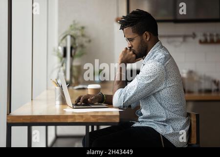 Thoughtful young mixed race businessman working on computer. Stock Photo