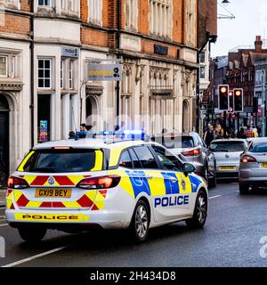 Epsom Surrey London UK, October 31 2021, Police Car Responding To An Emergency Call With Blue Lights On Stopped At Red Traffic Lights Stock Photo