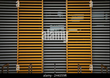 window blinds made of wood in orange and gray and metal square tubes and glare in the window Stock Photo