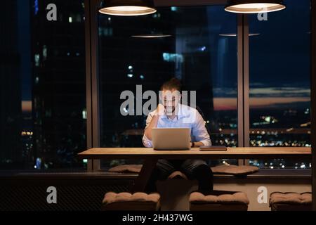 Thoughtful happy young african american male manager working on laptop. Stock Photo