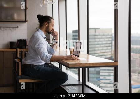 Concentrated young african american businessman analyzing online sales. Stock Photo