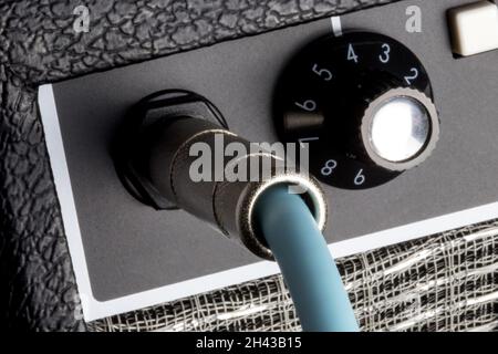 Amplifier front panel with plugged in guitar cable closeup Stock Photo