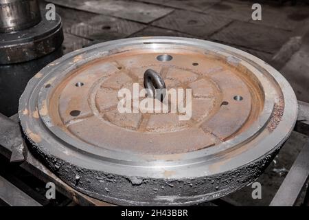 Eye bolt mounting in cast iron manhole, production of manholes at the factory. Stock Photo