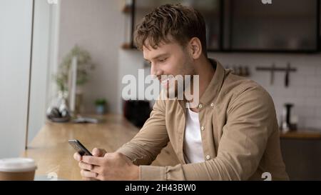 Happy handsome young man using cellphone apps. Stock Photo