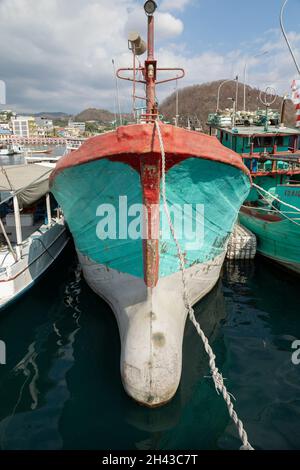 Labuan Bajo, Indonesia - Aug 25, 2019: A fishing boat, painted in turquoise blue, moored in the port of Labuan Bajo Stock Photo