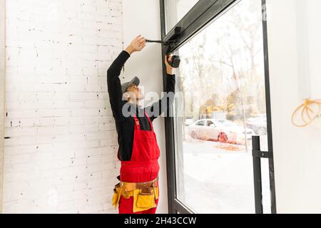 Construction Worker Installing New Windows In House Stock Photo