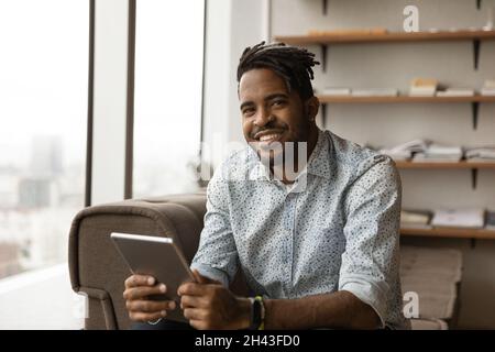 Portrait of smiling young african man holding digital tablet. Stock Photo