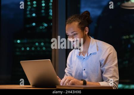 Smiling young african american businessman working on computer. Stock Photo