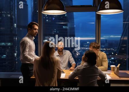 Concentrated young mixed race employees discussing project ideas. Stock Photo