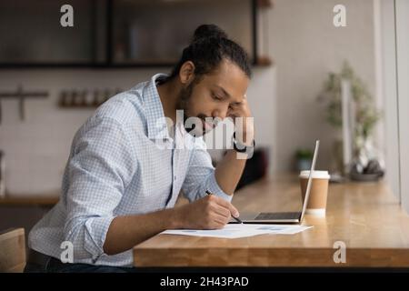 Focused young african american businessman working with documents. Stock Photo