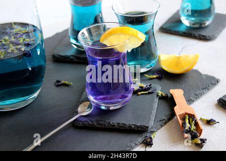 Healthy drinks, organic blue butterfly pea flower tea with limes and lemons, grey concrete background copy space top view Stock Photo