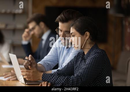 Concentrated mixed race team working on online project. Stock Photo