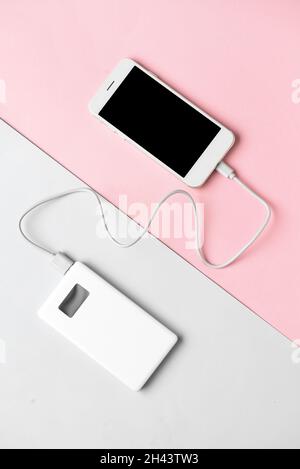New power bank and mobile phone on color background Stock Photo