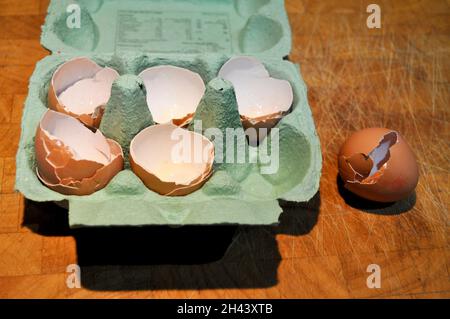 Empty egg shells in an egg box on a wooden background Stock Photo