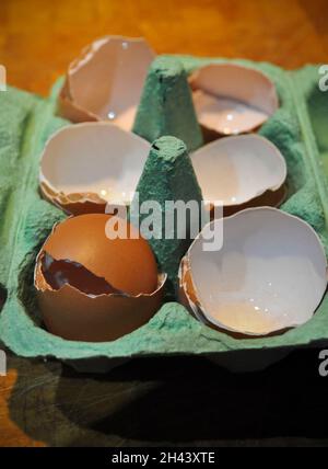 Empty egg shells in an egg box on a wooden background Stock Photo