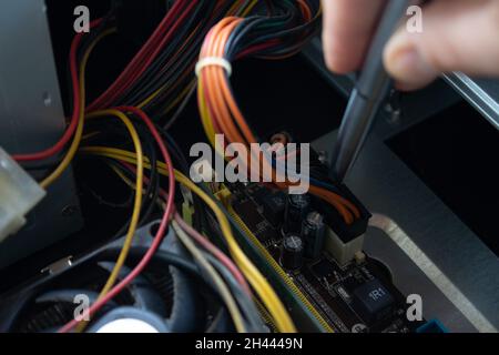 Man hand pointing out some computer pieces in a old dusty and dirty family computer. Stock Photo