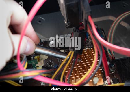 Man hand pointing out some computer pieces in a old dusty and dirty family computer. Stock Photo