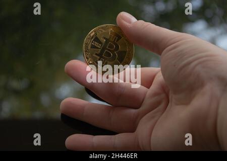 Man hand holding some bitcoin in different variations. Bitcoin is the most valuable currency on the earth for now. Stock Photo