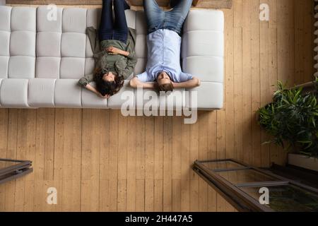 Couple put hands behind head relaxing on sofa, above view Stock Photo