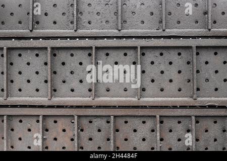 Old iron structures or plates with a round steel pattern of holes background. Stock Photo