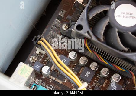 Man hand putting electrical connections of a computer in right sockets to run computer properly. Power cable connections. Stock Photo