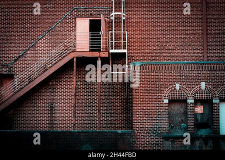 Iron fire escape and birck facade with teal trim and keep out sign Stock Photo