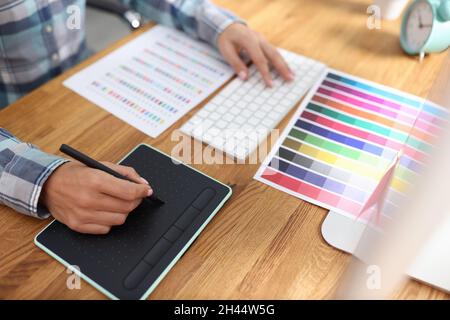 Graphic designer works on computer and selects color schemes Stock Photo