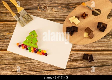 Assorted chocolates decorated in an artistic palette on a warm wooden background. Concept - a drawing with chocolate, a picture for a cafe, a concept Stock Photo