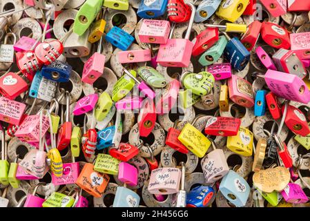 A wall full of padlocks of many shapes and colors on a street in Seoul, South Korea Stock Photo