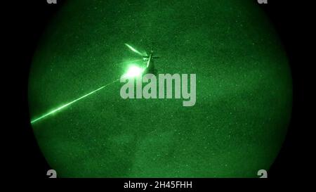 Rounds from a Dillon Aero M134D mini-gun are fired at a targeted area during a night time live fire as part of Exercise Phoenix Fires held at Mosul Dam, Iraq, on October 26, 2021.  The exercise partnered Coalition Joint Terminal Attack Controllers (JTAC) with Iraqi Terminal Attack Controllers (ITAC) to enhance Iraqi forces’ ability to engage in close air support. (U.S. Army Photo by Spc. Trevor Franklin) Stock Photo