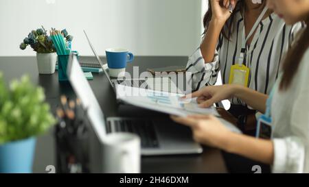 Cropped image of business female employees working together in the office with financial business budget plan papers. Stock Photo