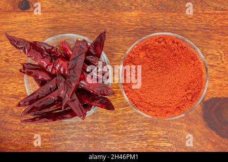 Top view of dry red chillies and red chilli powder bowls kept side by side Stock Photo