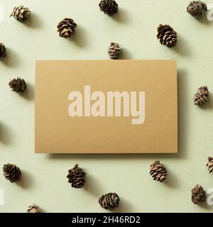 Blank memo pad with pine cones on khaki green background. autumn and winter concept Stock Photo