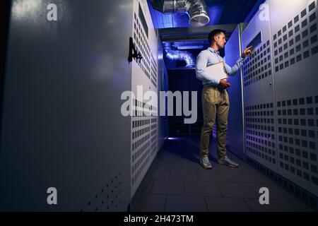 Experienced technician performing visual inspection of server hardware Stock Photo