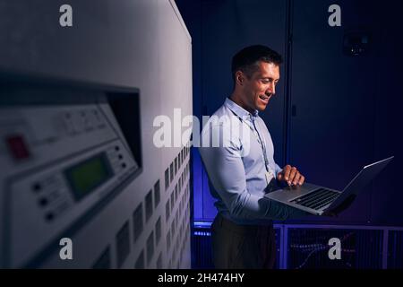 Cheerful male employee working in data center Stock Photo