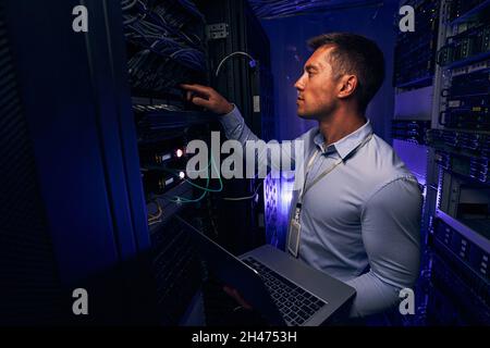 Experienced IT male technician monitoring server performance Stock Photo