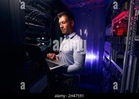 Pleased IT professional typing on his notebook computer Stock Photo