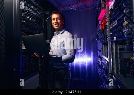 Joyous system administrator with laptop colocation data center Stock Photo