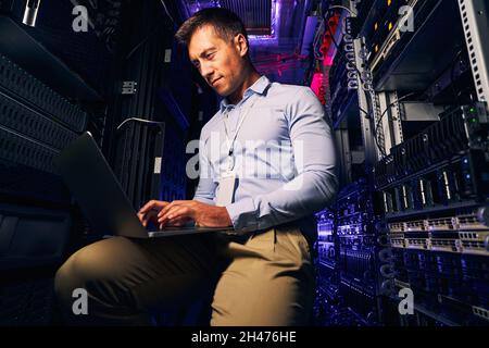 Focused experienced system administrator testing networking equipment Stock Photo