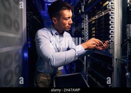 Professional engineer installing equipment in data center Stock Photo