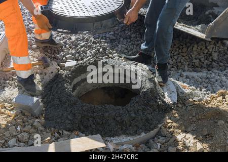 Construction of sewerage installing a sewer manhole on septic tank made concrete rings. Stock Photo