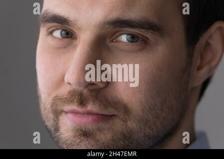 Close up handsome young man with bristle looking at camera. Stock Photo