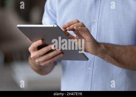 Close up young man using digital computer tablet applications. Stock Photo