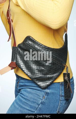 Black leather woman clutch on woman body in blue jeans isolated Stock Photo