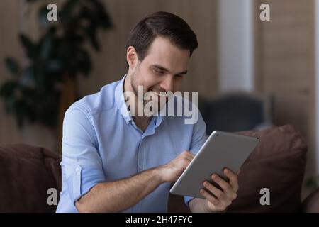 Smiling young man using digital computer tablet. Stock Photo